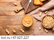 Чаша с вкусным арахисовым маслом на деревянном фоне. Стоковое фото, фотограф Pixel_shot / Фотобанк Лори
