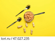 Горшок с вкусным арахисовым маслом, орехами и ложкой на цветном фоне. Стоковое фото, фотограф Pixel_shot / Фотобанк Лори