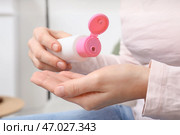 Молодая женщина, использующая дезинфицирующее средство дома, крупным планом. Стоковое фото, фотограф Pixel_shot / Фотобанк Лори