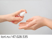 Люди с дезинфицирующим средством на сером фоне. Стоковое фото, фотограф Pixel_shot / Фотобанк Лори