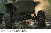 Close-up of the muddy front end of a prepared off-road vehicle for heavy off-roading. A vehicle making its way through an obstacle course. The SUV has big wheels with wicked tread. Стоковое фото, фотограф Воловодов Владимир / Фотобанк Лори
