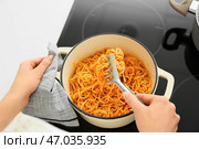 Женщина готовит вкусную пасту на кухне. Стоковое фото, фотограф Pixel_shot / Фотобанк Лори