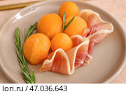 Тарелка с вкусной дыней и ветчиной прошутто на цветном фоне, крупным планом. Стоковое фото, фотограф Pixel_shot / Фотобанк Лори