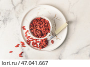 Чаша и ложка с сушеными ягодами годжи на светлом фоне. Стоковое фото, фотограф Pixel_shot / Фотобанк Лори