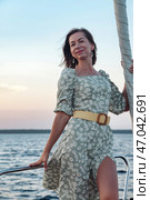 Conceptual Design of a Modern Yacht Sailing at Sunset With a Stylish Woman Onboard. Стоковое фото, фотограф Aleksandr Golubev / Фотобанк Лори