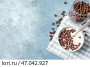 Чаша с шоколадными кукурузными шариками и молоком на цветном фоне. Стоковое фото, фотограф Pixel_shot / Фотобанк Лори
