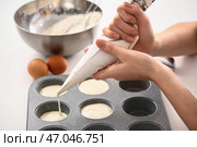Молодая женщина-кондитер готовит кексы на кухне. Стоковое фото, фотограф Pixel_shot / Фотобанк Лори