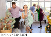 Middle-aged man and elderly woman are dancing contemporary twist in couple in Christmas atmosphere. Стоковое фото, фотограф Яков Филимонов / Фотобанк Лори