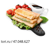 Грифельная тарелка с вкусными жареными блинчиками с начинкой на белом фоне. Стоковое фото, фотограф Pixel_shot / Фотобанк Лори