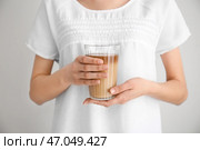 Женщина, держащая стакан вкусного фраппе кофе на светлом фоне, близком расстоянии. Стоковое фото, фотограф Pixel_shot / Фотобанк Лори