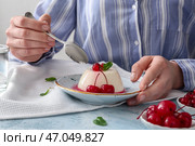 Женщина ест вкусную панна котту за столом. Стоковое фото, фотограф Pixel_shot / Фотобанк Лори