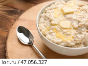 Чаша с вкусной овсяной кашей на деревянной доске, крупным планом. Стоковое фото, фотограф Pixel_shot / Фотобанк Лори