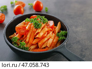 Кастрюля с вкусной пастой пенне в томатном соусе на столе. Стоковое фото, фотограф Pixel_shot / Фотобанк Лори