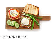 Деревянная доска с вкусными яйцами Бенедикт на белом фоне. Стоковое фото, фотограф Pixel_shot / Фотобанк Лори