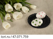 Яйца куриные пасхальные белые раскрашенные, тюльпаны белые на льняной скатерти, концепция Светлой Пасхи. Стоковое фото, фотограф Оксана Шведкова / Фотобанк Лори