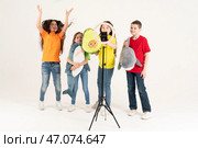 A group of children bloggers shoot video on the phone. Selfies The phone is mounted on a modern round lamp with a tripod (2020 год). Редакционное фото, фотограф Луиза Налимова / Фотобанк Лори