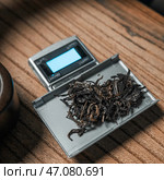 Measuring Loose Tea Leaves Accurately Using a Digital Scale for Optimal Brewing Results. Стоковое фото, фотограф David Kashakhi / Фотобанк Лори