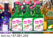 Бутылки Soju Jinro персик на полке в супермаркете. Soju — традиционный корейский алкогольный напиток. Редакционное фото, фотограф FotograFF / Фотобанк Лори