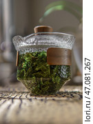 A Beautiful Teapot Brimming with Fresh Green Tea Leaves and Herbal Infusions for Brewing. Стоковое фото, фотограф David Kashakhi / Фотобанк Лори