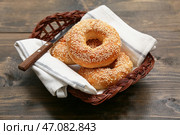 Плетёная корзина с вкусными бубликами с кунжутом на деревянном фоне. Стоковое фото, фотограф Pixel_shot / Фотобанк Лори