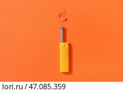 Зажигалка с бумажным пламенем на оранжевом фоне. Стоковое фото, фотограф Pixel_shot / Фотобанк Лори