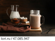 Банка с крышкой, наполненная сладким шоколадным молоком, и миска с какао-порошком на деревянном фоне. Стоковое фото, фотограф Pixel_shot / Фотобанк Лори