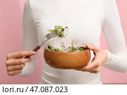 Женщина держит миску с салатом с пластиком на розовом фоне, крупный план. Месяц осведомленности о микропластике. Стоковое фото, фотограф Pixel_shot / Фотобанк Лори