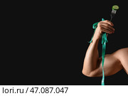 Культурист-мужчина с мерной лентой и ломтиком огурца на черном фоне, крупным планом. Стоковое фото, фотограф Pixel_shot / Фотобанк Лори