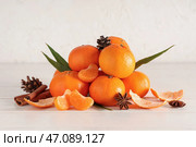 Сладкие мандарины с корицей, шишками и звездчатым анисом на белом деревянном столе возле грубого фона. Стоковое фото, фотограф Pixel_shot / Фотобанк Лори