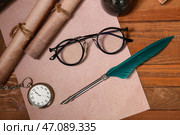 Лист бумаги с перьевой ручкой, свитки, карманные часы и очки на деревянном фоне. Стоковое фото, фотограф Pixel_shot / Фотобанк Лори