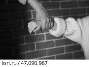 Разгневанная мать, схватившая свою маленькую дочь за руку на фоне кирпичной стены, крупным планом. Концепция домашнего насилия. Стоковое фото, фотограф Pixel_shot / Фотобанк Лори