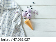 Вафельный рожок с вкусным черничным мороженым на белом столе. Стоковое фото, фотограф Pixel_shot / Фотобанк Лори