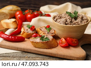 Доска с тостами, миска с вкусным паштетом, петрушка, перец чили и помидоры на деревянном фоне. Стоковое фото, фотограф Pixel_shot / Фотобанк Лори