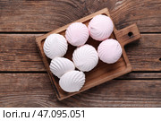 Вкусные зефирки на разделочной доске на деревянном фоне. Вид сверху. Стоковое фото, фотограф Pixel_shot / Фотобанк Лори