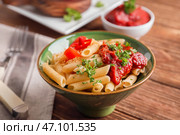 Чаша с вкусной пастой пенне и соусом Болоньезе на деревянном столе. Стоковое фото, фотограф Pixel_shot / Фотобанк Лори