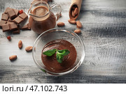 Стеклянная чаша с вкусным растопленным шоколадом на деревянном столе. Стоковое фото, фотограф Pixel_shot / Фотобанк Лори