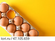 Треснутые и цельные куриные яйца в картонной коробке на столе с цветом. Стоковое фото, фотограф Pixel_shot / Фотобанк Лори