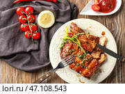 Тарелка с вкусными жареными ребрышками на столе. Стоковое фото, фотограф Pixel_shot / Фотобанк Лори