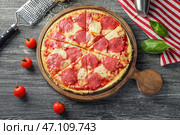 Деревянная доска с вкусной пиццей пепперони на столе. Стоковое фото, фотограф Pixel_shot / Фотобанк Лори