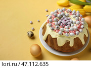 Композиция со сладким куличом, яйцами и тюльпанами на цветном фоне. Стоковое фото, фотограф Pixel_shot / Фотобанк Лори
