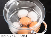 Стеклянная кастрюля с кипящими яйцами на плите на кухне, крупным планом. Стоковое фото, фотограф Pixel_shot / Фотобанк Лори