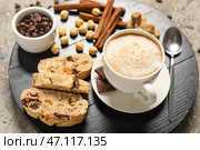 Доска с вкусным печеньем бискотти, чашкой кофе, фундуком и корицей на сером фоне. Стоковое фото, фотограф Pixel_shot / Фотобанк Лори