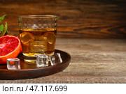 Стакан рома со льдом и сицилийским апельсином на столе. Стоковое фото, фотограф Pixel_shot / Фотобанк Лори