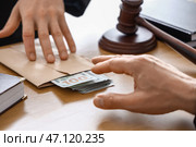 Зрелый судья берет взятку у мужчины в зале суда, крупным планом. Стоковое фото, фотограф Pixel_shot / Фотобанк Лори