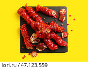 Сланцевая доска с вкусным чурчхела и гранатом на желтом фоне. Стоковое фото, фотограф Pixel_shot / Фотобанк Лори