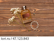 Флакон парфюма, женские аксессуары и цветы гипсофилы на деревянном фоне. Стоковое фото, фотограф Pixel_shot / Фотобанк Лори