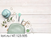 Композиция с косметичкой, стильными женскими аксессуарами, кистями для макияжа и бутылкой духов на светлом деревянном фоне. Стоковое фото, фотограф Pixel_shot / Фотобанк Лори