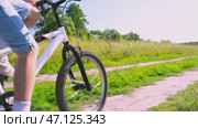 The boy rides a bicycle in the park. Стоковое видео, видеограф Igor Skripachev / Фотобанк Лори