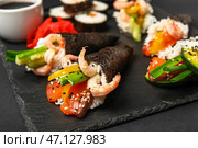 Сланцевая доска с вкусными конусами суши на темном фоне, крупным планом. Стоковое фото, фотограф Pixel_shot / Фотобанк Лори