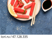 Тарелка с вкусными крабовыми палочками и соусом на синем фоне. Стоковое фото, фотограф Pixel_shot / Фотобанк Лори